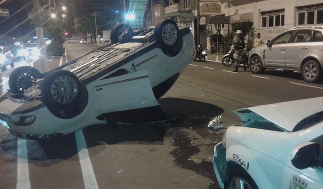 Veículo capota ao colidir com táxi na Avenida da Paz, em Maceió