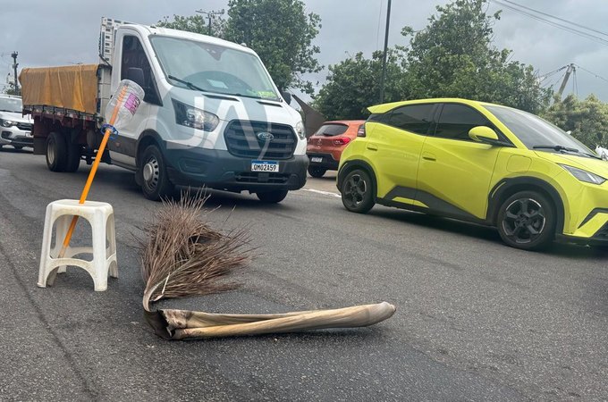 Populares sinalizam rua com galhos e bancos para evitar acidentes, após derramamento de diesel, em Arapiraca