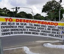 Jovem chama atenção ao utilizar faixa para pedir emprego em avenida de Maceió