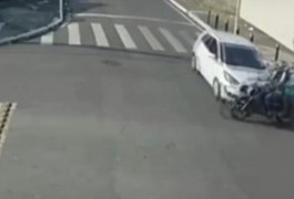 Casal é arremessado de moto após furar cruzamento e ser atingido por carro; assista