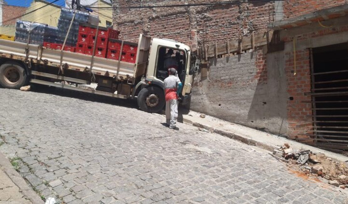 Caminhão com carga de bebidas colide em muro de imóvel em Santana do Ipanema