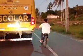 Jovem em bicicleta arrisca a vida em rodovia se segurando na traseira de ônibus, em Taquarana