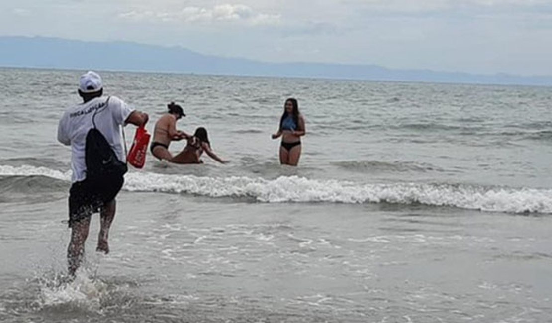 Homem salva criança de ataque de cachorro dentro da água na praia