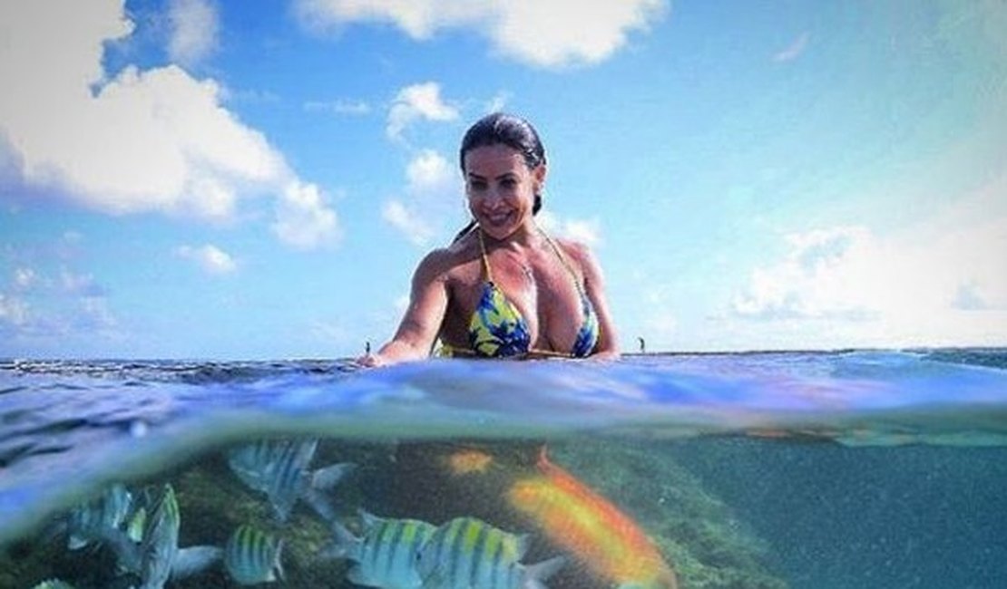 Scheila Carvalho posa vestida de sereia em meio a peixes no mar