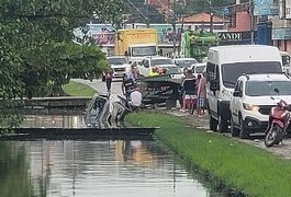 Carro bate em caçamba de lixo e cai em córrego de Maceió