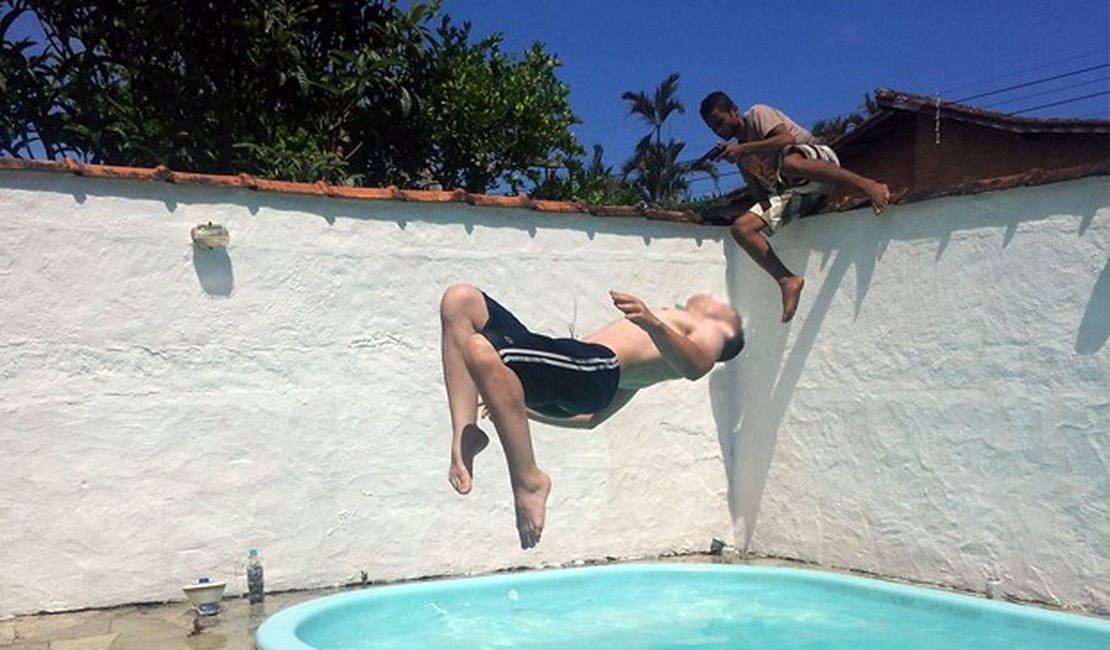 Mulher fotografa brincadeira na piscina e flagra ladrão invadindo a casa