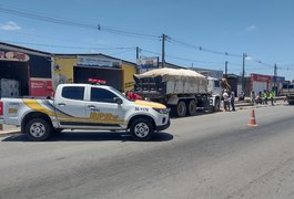 Caçamba com carga de areia atinge veículo, invade canteiro e colide contra poste em Arapiraca