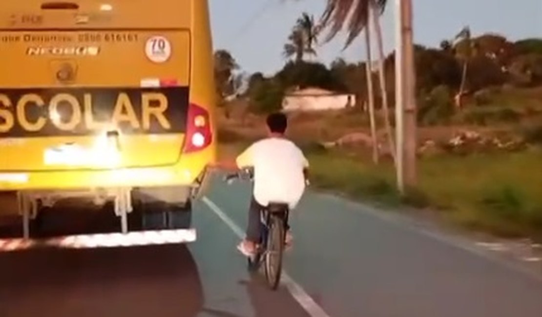 Jovem em bicicleta arrisca a vida em rodovia se segurando na traseira de ônibus, em Taquarana