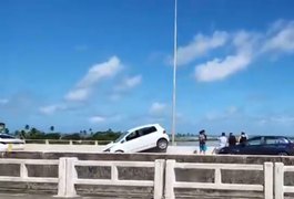 Carro atinge casal de ciclistas e fica pendurado em mureta de proteção da Ponte Divaldo Suruagy