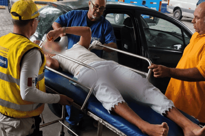 Jovem baleado é escoltado até o HGE após ataque em ponto de ônibus, em Maceió