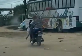 Vídeo. Motociclista é flagrado dirigindo sem capacete e transportando antena parabólica, em Arapiraca