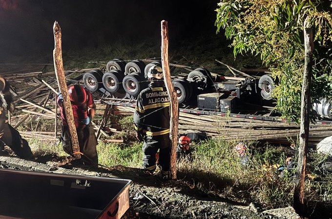 Motorista morre após carreta carregada de madeira tombar na AL-105, em Maceió