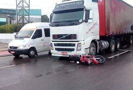 Motocicleta fica embaixo de carreta após acidente em Arapiraca