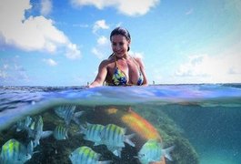 Scheila Carvalho posa vestida de sereia em meio a peixes no mar