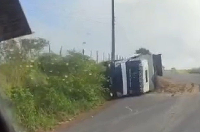 Caminhão-caçamba tomba na AL-487 e carga de areia fica espalhada pela rodovia, em Girau