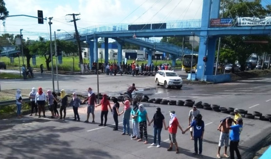 Grupo de manifestantes com rostos cobertos bloqueia a BR-104, na entrada da UFAL em Maceió