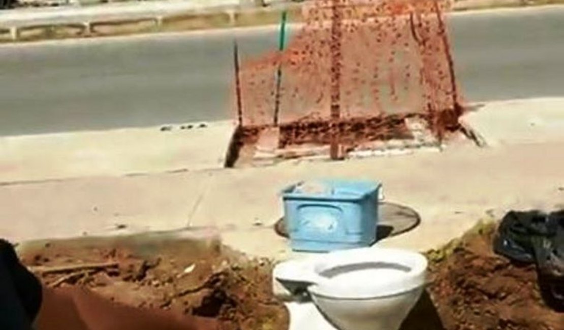 Vendedor tenta instalar banheiro em uma tubulação de água às margens de rodovia em Maceió