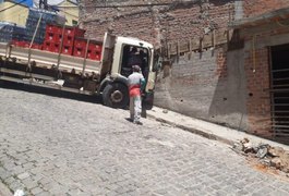 Caminhão com carga de bebidas colide em muro de imóvel em Santana do Ipanema