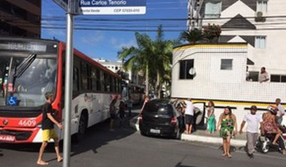 Motorista não respeita sinalização, bate em ônibus e colide contra muro de prédio