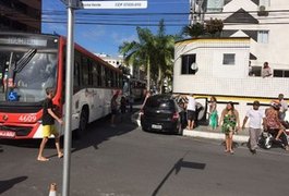 Motorista não respeita sinalização, bate em ônibus e colide contra muro de prédio