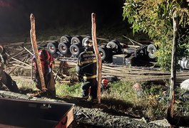 Motorista morre após carreta carregada de madeira tombar na AL-105, em Maceió
